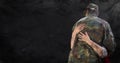 Back of soldier being hugged against black grunge background with overlay and flare