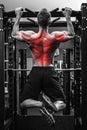 Back specialization in bodybuilidng. Man doing pull-ups on a horizontal bar