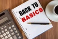 BACK TO BASICS written in a white notepad near a calculator and a cup of coffee on a dark wooden background Royalty Free Stock Photo