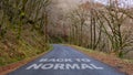 Back to Normal written on a country lane in a wood
