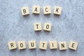 Back to routine text Game tiles on grey flecked stone background Royalty Free Stock Photo