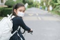 Back to school. asian child girl wearing face mask with backpack biking a bicycle and going to school .Covid-19 coronavirus Royalty Free Stock Photo