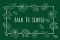 Back to School. Autumn leaves are drawn with chalk on the dark green chalkboard.