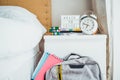 Back to school background. Backpack with notebooks near bed and bedside table with lightened box with hashtag message, alarm clock