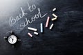 Back to school background on blackboard with colorful chalks and alarm clock. Royalty Free Stock Photo