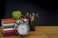 Back to school background with books and alarm clock over chalkboard Royalty Free Stock Photo