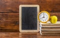 Back to school background with books and alarm clock over chalkboard Royalty Free Stock Photo