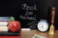 Back to school background with books and alarm clock over chalkboard Royalty Free Stock Photo