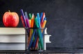 Back to school background with books and apple over blackboard with copy space Royalty Free Stock Photo