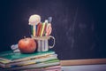 Back to school background with books and apple over blackboard Royalty Free Stock Photo