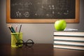 Back to school background with books, pencils and apple over chalkboard and wooden table Royalty Free Stock Photo