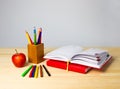 Back to school background with books, pencils and apple over wooden table Royalty Free Stock Photo