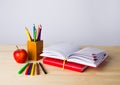 Back to school background with books, pencils and apple over wooden table Royalty Free Stock Photo