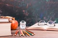 Back to school background with books, pencils, clock,  open book and glasses on a wooden table Royalty Free Stock Photo