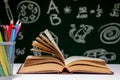 Back to school background with books, pencils and globe on white table on a green blackboard background Royalty Free Stock Photo