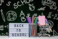 Back to school background with books, pencils and globe on white table on a green blackboard background Royalty Free Stock Photo