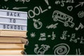 Back to school background with books, pencils and globe on white table on a green blackboard background Royalty Free Stock Photo