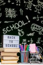 Back to school background with books, pencils and globe on white table on a green blackboard background Royalty Free Stock Photo