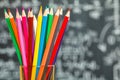 Back to school background with colorful felt pens and blurred math formulas written by white chalk on the black school chalkboard Royalty Free Stock Photo