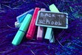 Back to school background with colorful neon colored crayons, on purple glowing background. Flat position, top view, copy space. Royalty Free Stock Photo