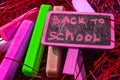 Back to school background with colorful neon colored crayons, on purple glowing background. Flat position, top view, copy space. Royalty Free Stock Photo