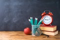 Back to school background with pencils, apple, books and alarm clock over chalkboard Royalty Free Stock Photo