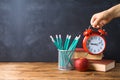 Back to school background with pencils, apple, books and alarm clock over chalkboard Royalty Free Stock Photo