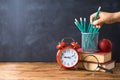 Back to school background with pencils, apple, books and alarm clock over chalkboard Royalty Free Stock Photo