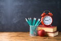 Back to school background with pencils, apple, books and alarm clock over chalkboard Royalty Free Stock Photo