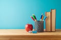 Back to school background with pencils, books and apple on wooden table over blue background Royalty Free Stock Photo