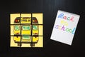 Back to school background with title `Back to school` and `school bus` written on the yellow pieces of paper