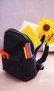 Back to School Black Backpack with Ruler Bright Pens Notebooks and Book on Table