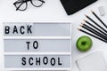 Back to School blocks with school supplies and green apple on white desk. Top view, flat lay Royalty Free Stock Photo