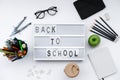 Back to School blocks with school supplies and green apple on white desk. Top view, flat lay Royalty Free Stock Photo