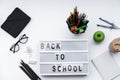 Back to School blocks with school supplies and green apple on white desk. Top view, flat lay Royalty Free Stock Photo