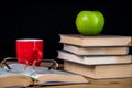 Back to school. Books, green apple, pencils and glasses on wooden table Royalty Free Stock Photo