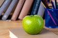 Back to school. Books, green apple, pencils and glasses on wooden table Royalty Free Stock Photo