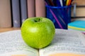 Back to school. Books, green apple, pencils and glasses on wooden table Royalty Free Stock Photo