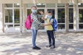 Back to school. Brother and sister, girl and boy with school backpacks go to study after a pandemic, quarantine or coronavirus. Royalty Free Stock Photo