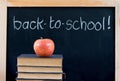 Back to school on chalkboard with apple & books Royalty Free Stock Photo