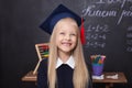 Back to school! Cheerful little girl at school on a black background. Looking into the camera. School concept. Schoolgirl in the c Royalty Free Stock Photo