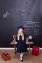 Back to school! Cheerful little girl at school is standing near the desk. Looking into the camera. School concept. Schoolgirl resp Royalty Free Stock Photo