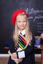 Back to school! Cheerful little girl stands with bills. School concept. Schoolgirl answers at lesson. The kid is studying in the c Royalty Free Stock Photo