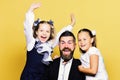Kids wearing school clothes and bows near bearded teacher