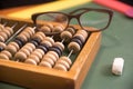 Back to school. Close-up of a schoolboy`s glasses, wooden abacus for math, chalk for writing, school board. Selective focus Royalty Free Stock Photo