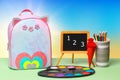 Back to school. Colorful school equipment, a bright school backpack and a blackboard with numbers 1 2 3 on green table over an Royalty Free Stock Photo