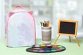 Back to school. Colorful school equipment, a bright school backpack with space for text and a empty blackboard on green table over Royalty Free Stock Photo