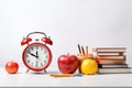 Back to school concept. Alarm clock, books, apple and pencils on white background, Orange alarm clock with red apple and school Royalty Free Stock Photo