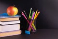 Back to school concept. Apple, books and school supplies painted over on a black board background. Copy space. Royalty Free Stock Photo