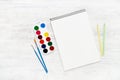 Back to school concept. Artist`s blank sketchbook on white wooden background with pencils, paints and brushes. Flat lay, copy Royalty Free Stock Photo